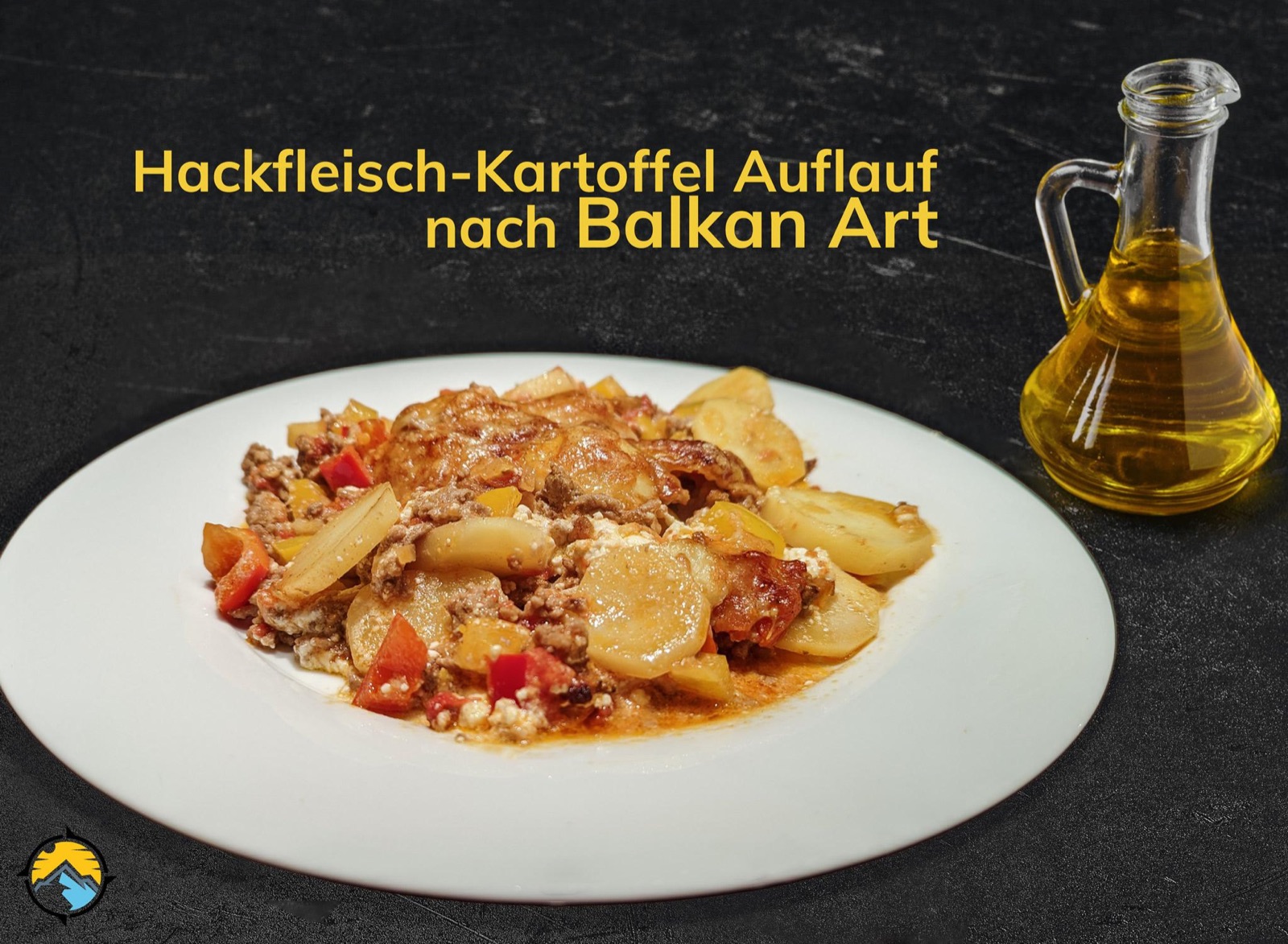 Hackfleisch-Kartoffel-Auflauf mit Paprika und Schafskäse auf einem weißen Teller, daneben eine Karaffe Olivenöl