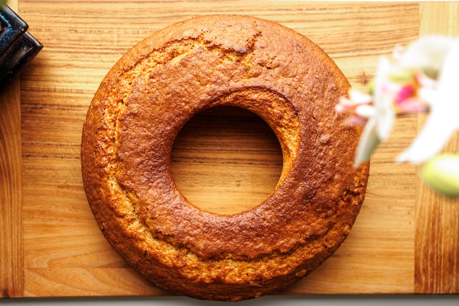 Möhrenkuchen von oben auf einem Holzbrett, Ringform mit Loch in der Mitte